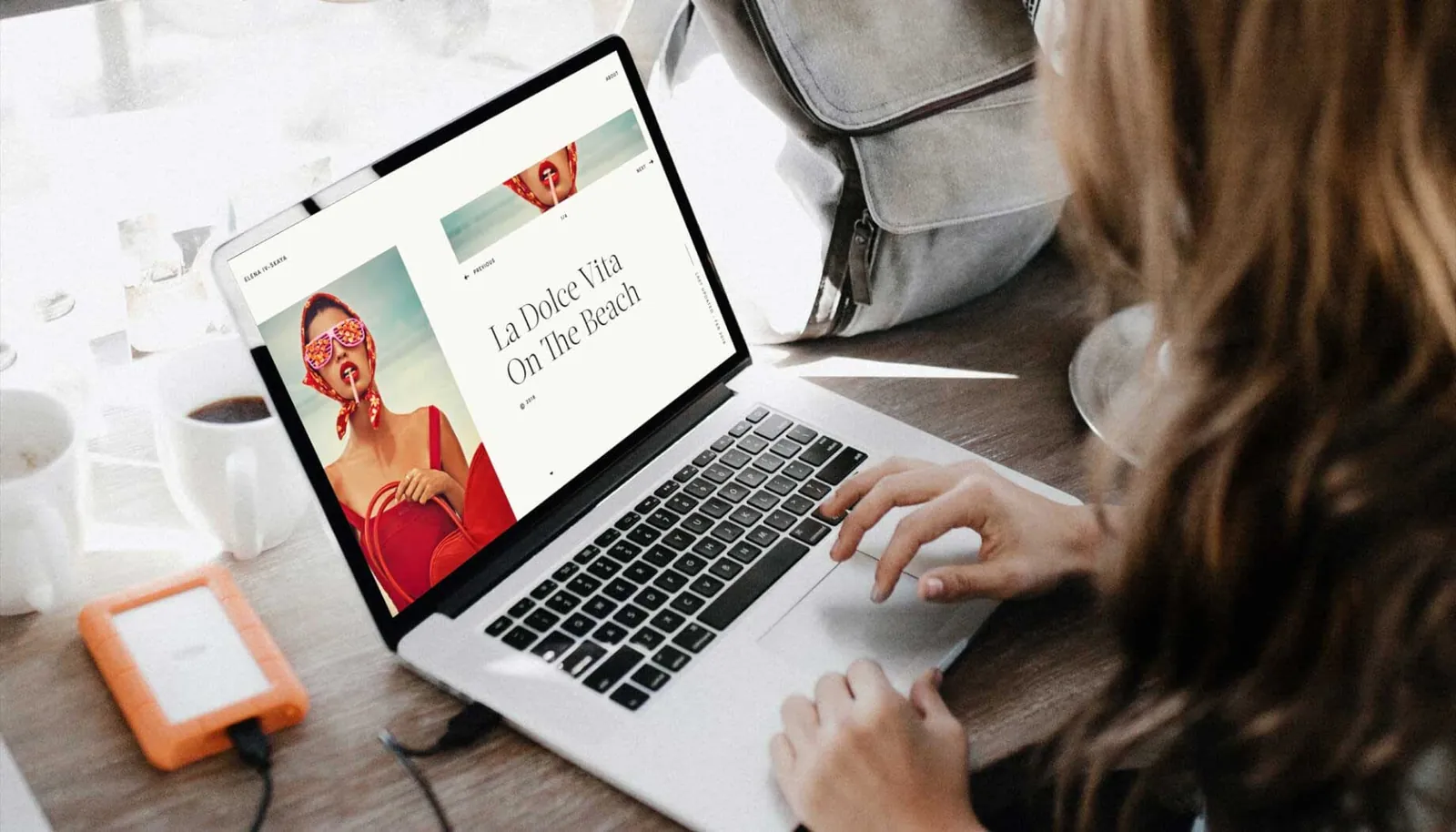 Handen op een laptop met een webdesign op het scherm